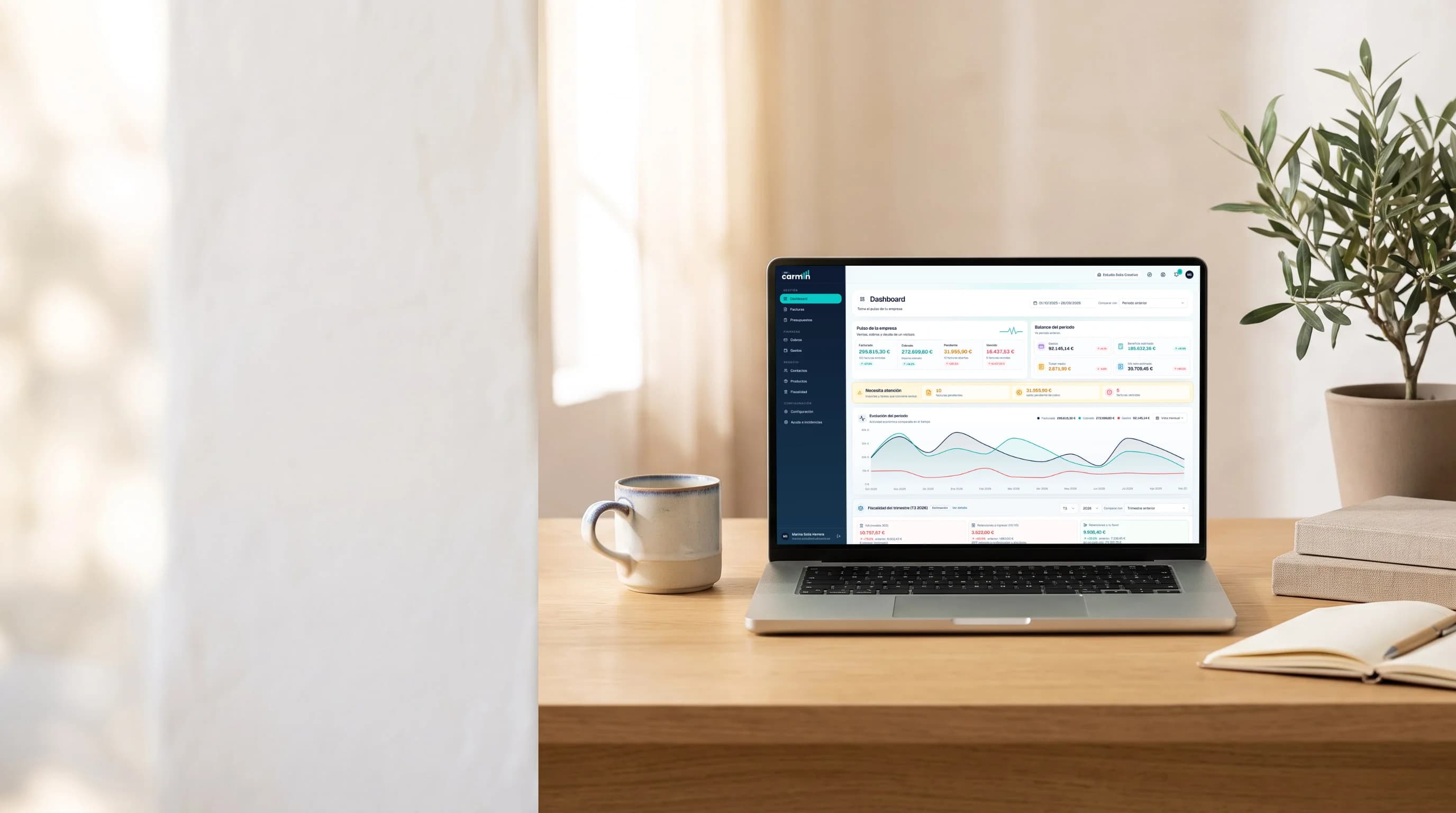Portátil sobre un escritorio con el dashboard de Carmin ERP: facturado, cobrado, pendiente, vencido y evolución del periodo