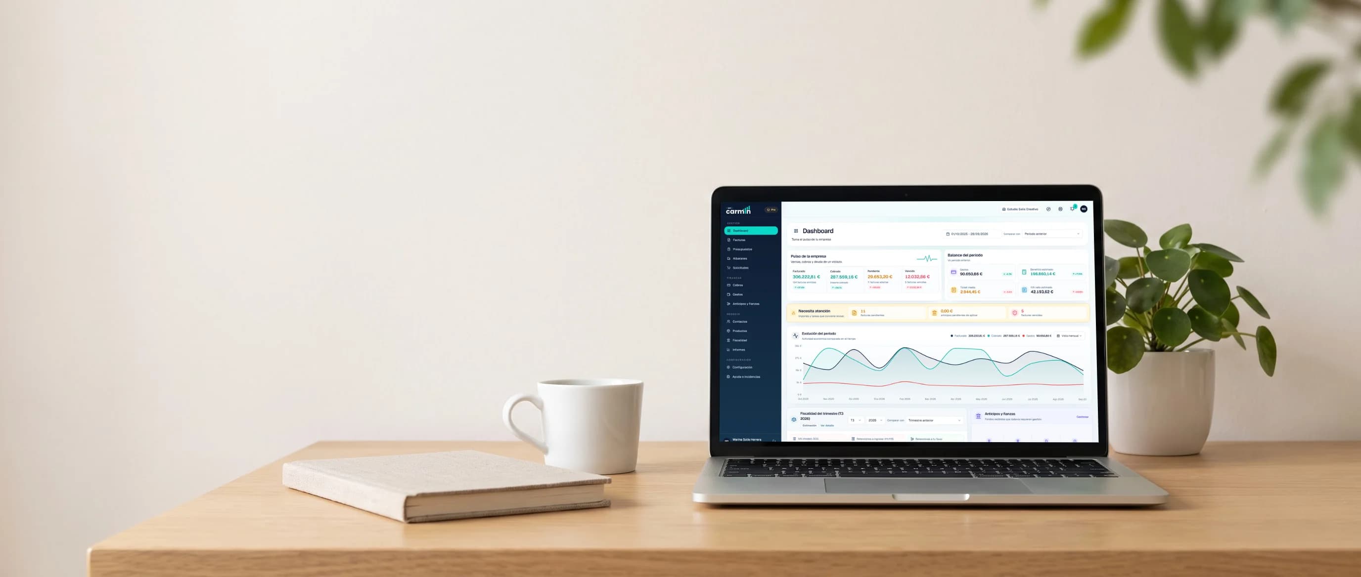 Portátil sobre un escritorio de madera con el dashboard de Carmin ERP: facturado, cobrado, pendiente, vencido y la evolución del periodo